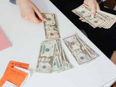 High-Angle Shot of a Person Counting Paper Money on White Table